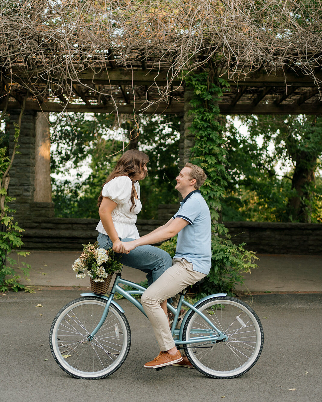 Couple face each other while riding a bike in a beautiful garden