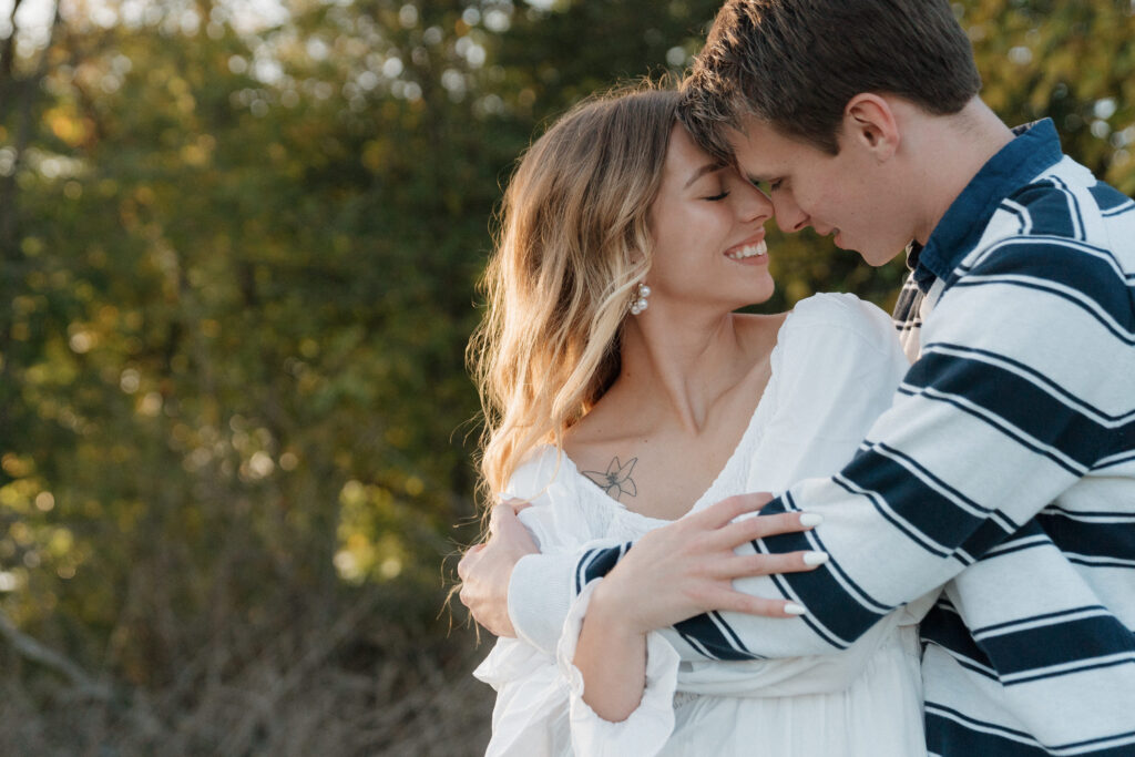 Couple hold each other close at sunset during their engagement photoshoot