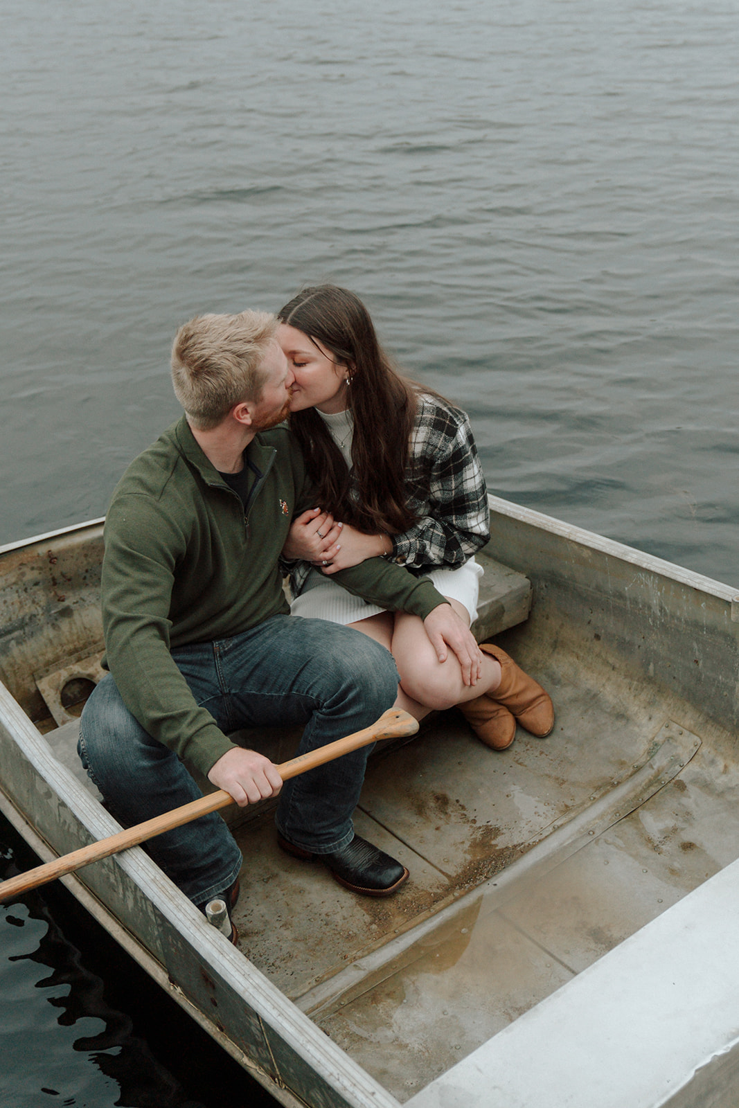 Engaged couple kiss in the back of a canoe on the water during the fall in Ohio