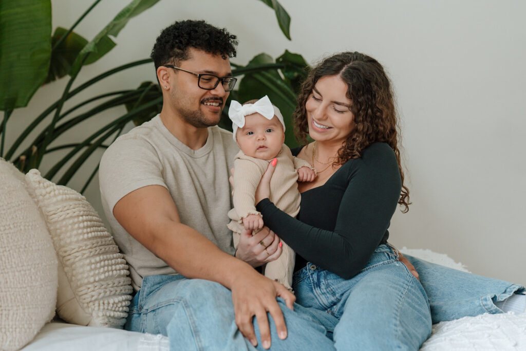 Mom and dad snuggle in with baby in studio family photo session