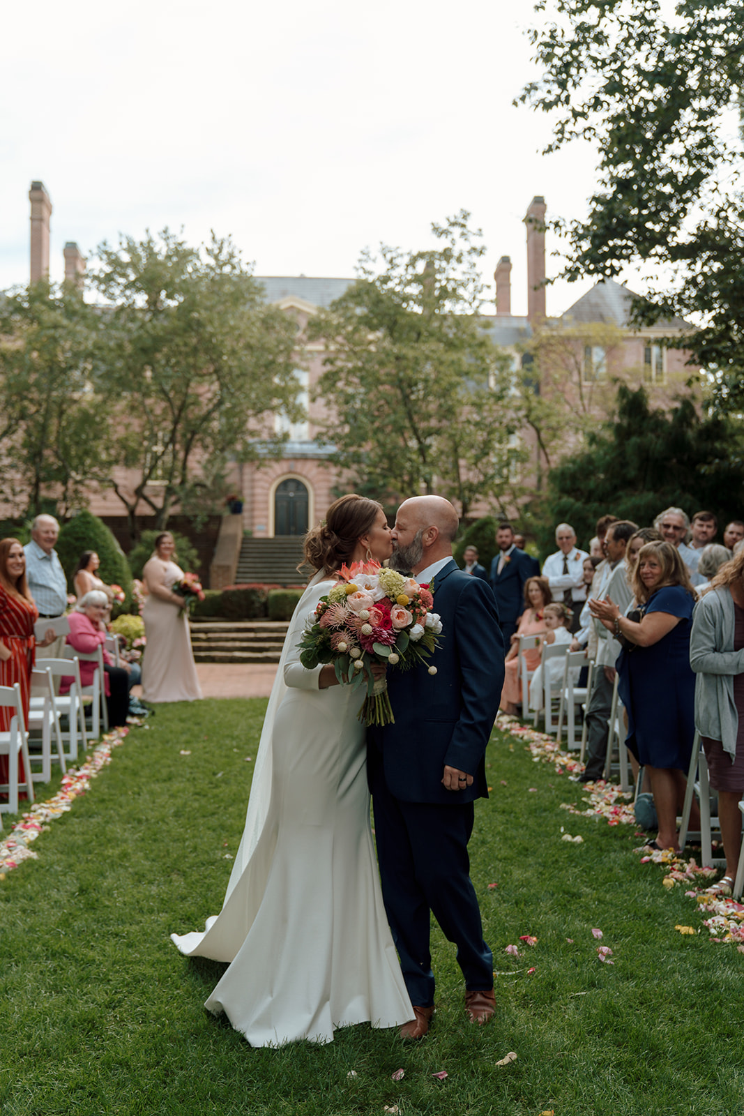 Bride and groom kiss in the aisle after their ceremony at Kingwood Center Gardens in Mansfield, Ohio