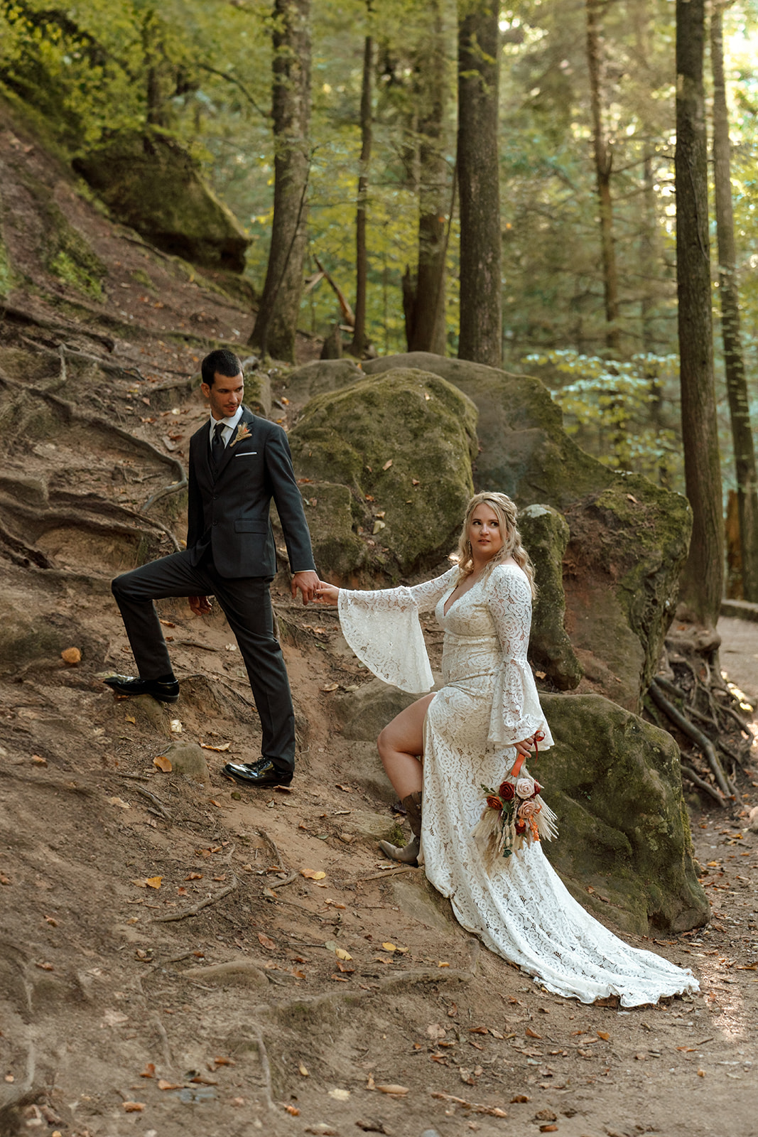 Couple walks together up rocky slope during elopement in Hocking Hills Ohio