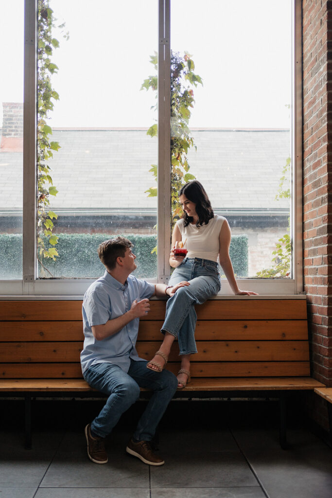 Couple looks at each other while enjoying cocktails at a social bar